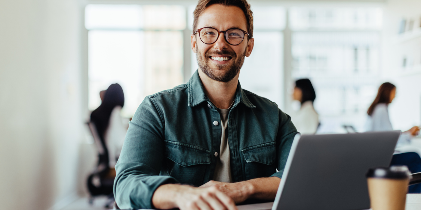 Mitarbeiter arbeitet am Laptop im Büro – Symbol für die Messung von Download-, Upload- und Reaktionszeiten eines Business-Internetanschlusses.