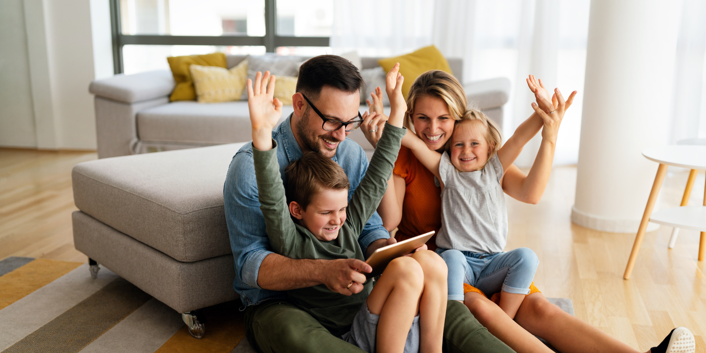 Eine Familie sitzt gemeinsam im Wohnzimmer und nutzt ein Tablet. Das Bild steht sinnbildlich für einen sicheren und entspannten Umgang mit digitalen Geräten – passend zum G DATA Sicherheitspaket und dem sicheren Start ins neue Jahr.