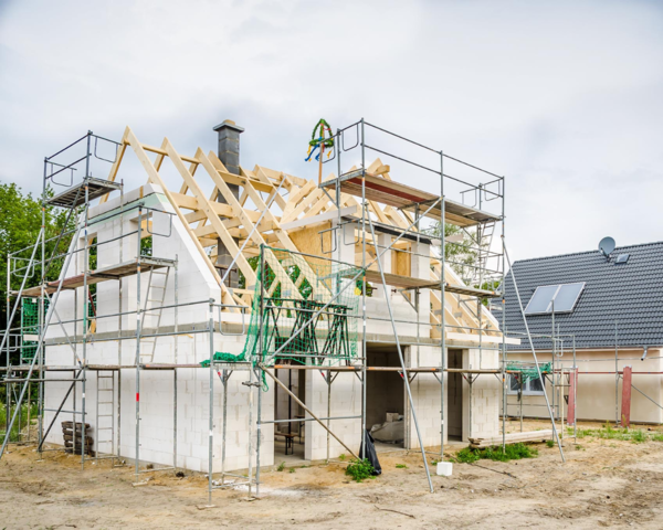 Haus in der Errichtung, noch ohne Dach und mit Baugerüst