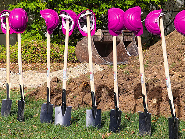 Schaufeln mit pinken Schutzhelmen