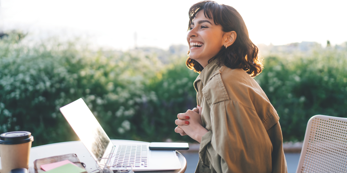 Eine junge Frau arbeitet zufrieden am Laptop – Symbol für starke, stabile und schnelle Glasfaser-Verbindungen von Grafschafter Breitband. Jetzt neue Glasfaserprodukte entdecken und sparen.